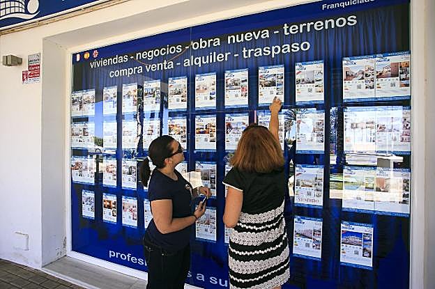 Dos mujeres miran anuncios de paquetes vacacionales.