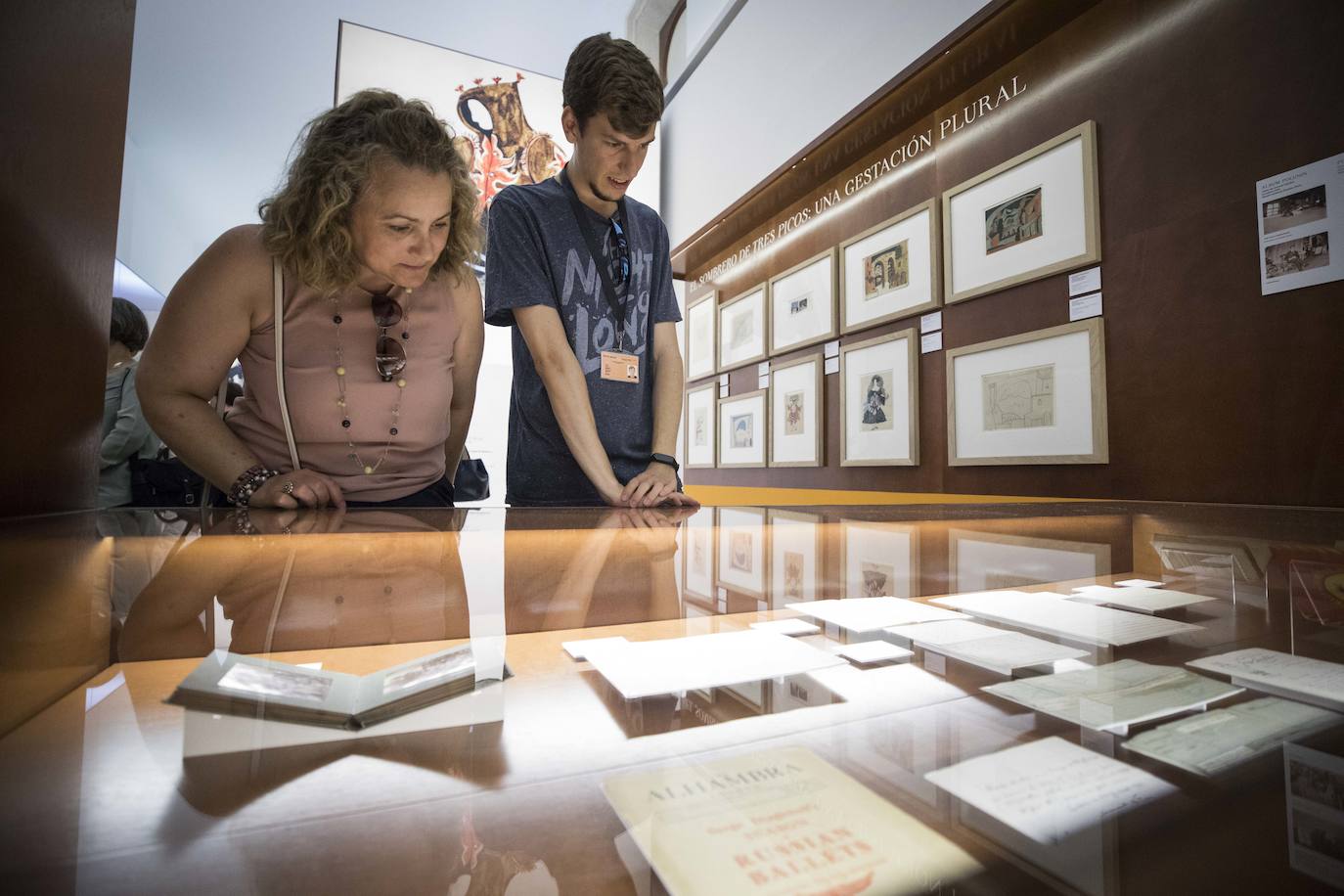 Dos visitantes observan documentos de la exposición.