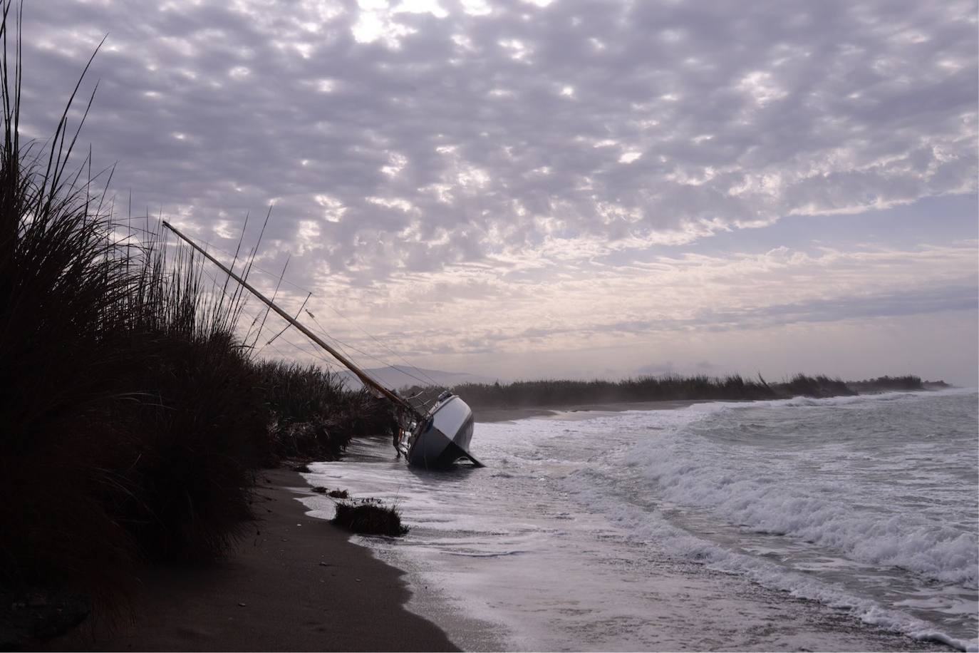 Fotos: Piden ayuda para sacar un velero de una playa de Salobreña