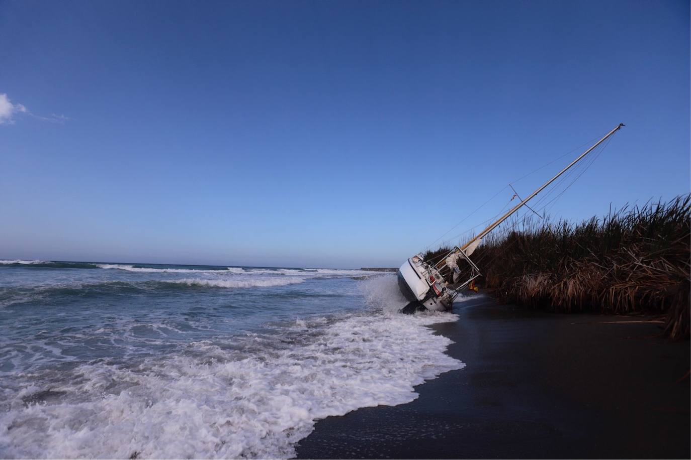 Fotos: Piden ayuda para sacar un velero de una playa de Salobreña