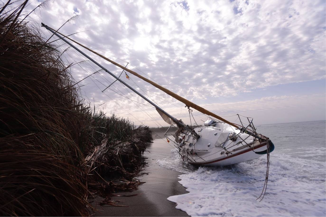 Fotos: Piden ayuda para sacar un velero de una playa de Salobreña