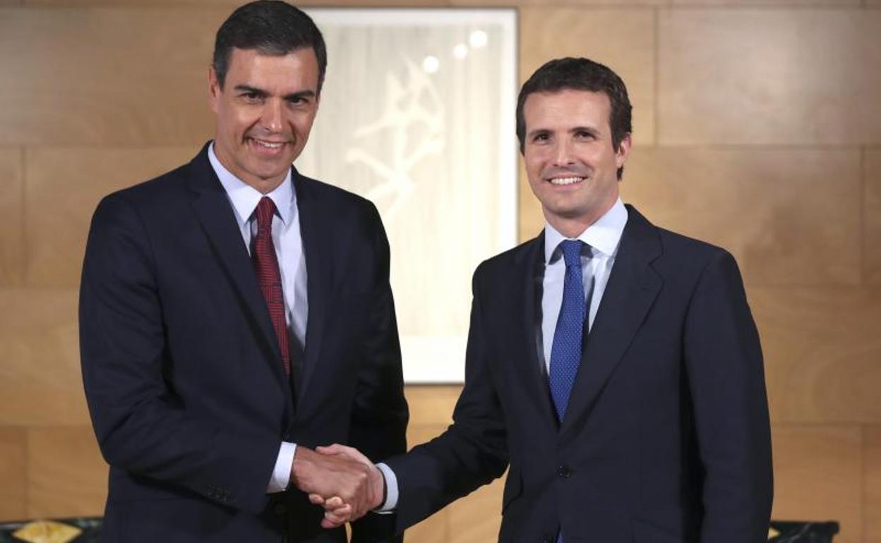El presidente del Gobierno en funciones, Pedro Sánchez (i) saluda al líder del PP, Pablo Casado.