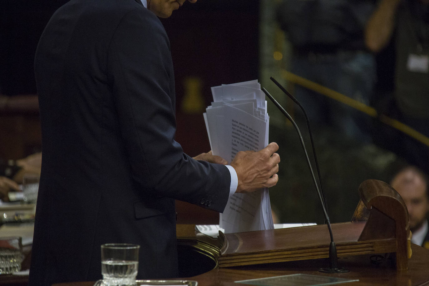 Pedro Sánchez coloca los folios que componen su discurso.