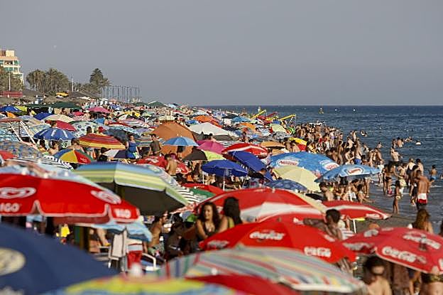 Los bañistas buscan un hueco para clavar la sombrilla en las playas de Salobreña.