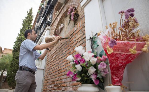 Rodrigo Bueno coloca un ramo de margaritas en la tumba sin nombre donde duerme el sueño de los justos Carlos Calderón y su familia.