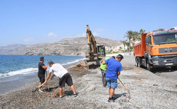 Los operarios limpian la playa de La Rábita para retirar los residuos del temporal.