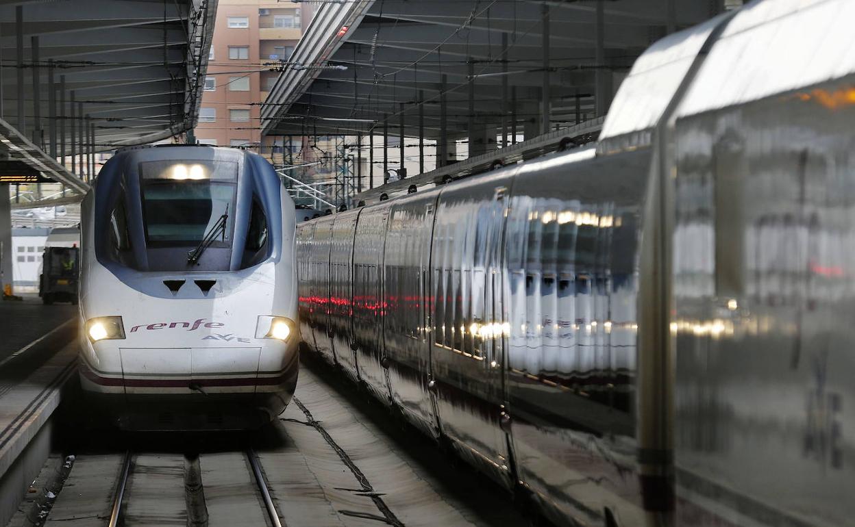 Un tren AVE de Renfe sale de una estación.