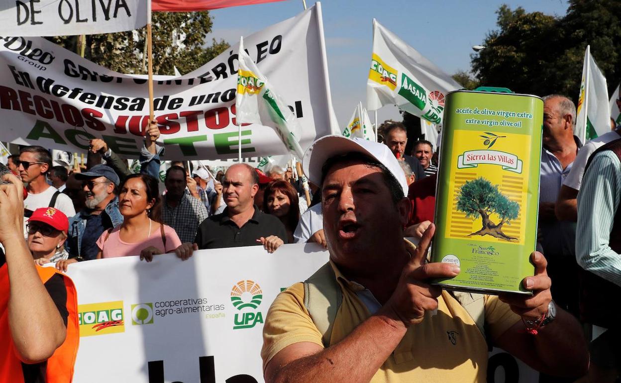 Uno de los manifestantes sujeta un recipiente con aceite de oliva. 