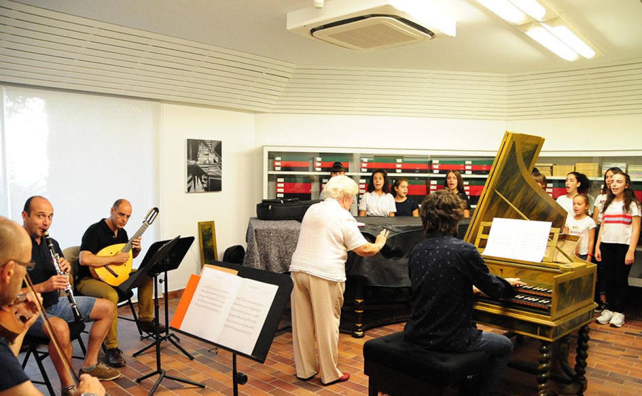 Ensayo del espectáculo, con Elena Peinado (de pie), el coro y los instrumentistas.