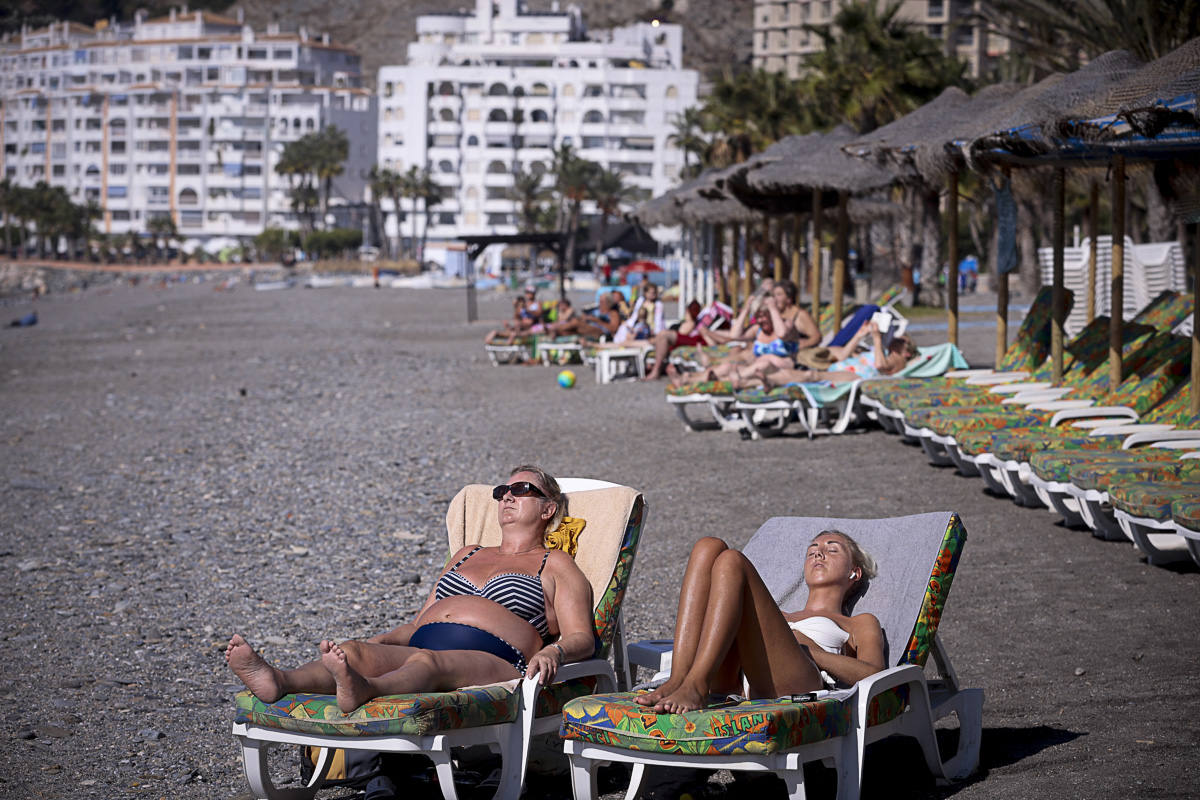 Decenas de turistas ya se encuentran en las playas del litoral granadino, que registrará una temperatura primaveral este fin de semana 