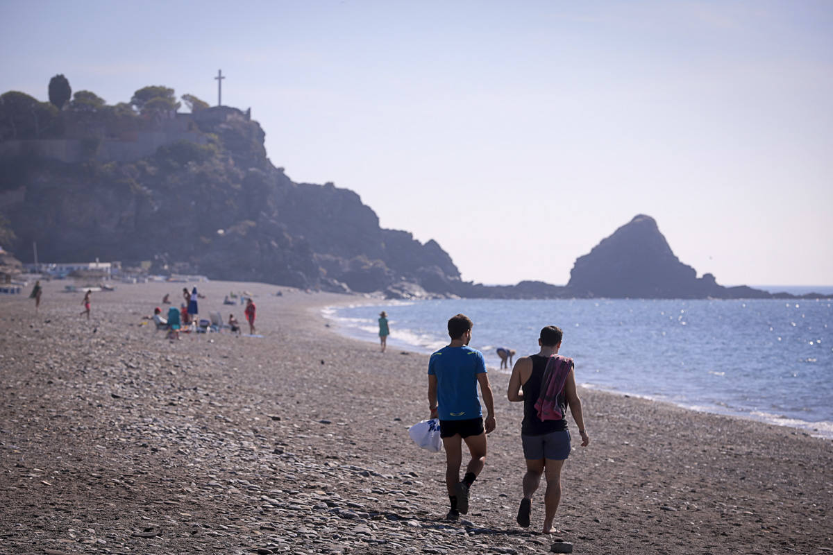 Decenas de turistas ya se encuentran en las playas del litoral granadino, que registrará una temperatura primaveral este fin de semana 