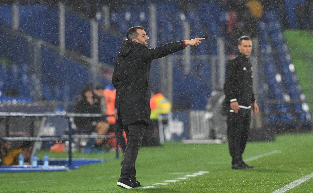 Diego Martínez ordena a sus futbolistas desde la banda bajo la lluvia. 