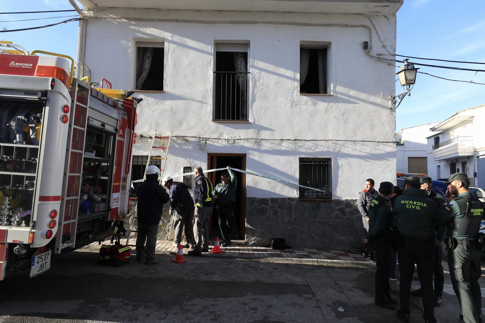 Miembros de la funeraria proceden a guardar uno de los féretros en el vehículo.