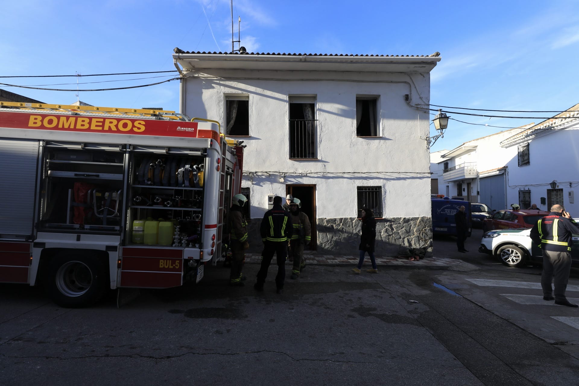 Miembros de la funeraria proceden a guardar uno de los féretros en el vehículo.