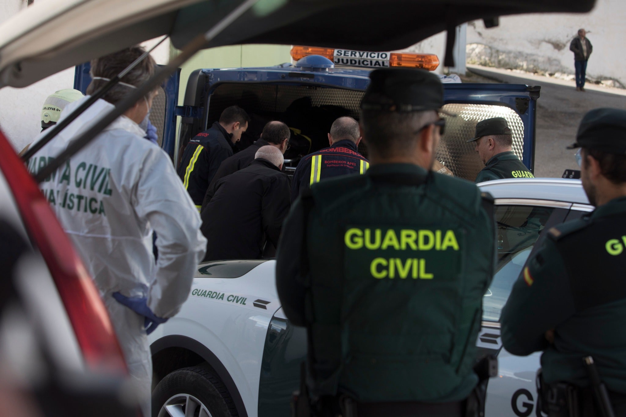 Miembros de la funeraria proceden a guardar uno de los féretros en el vehículo.