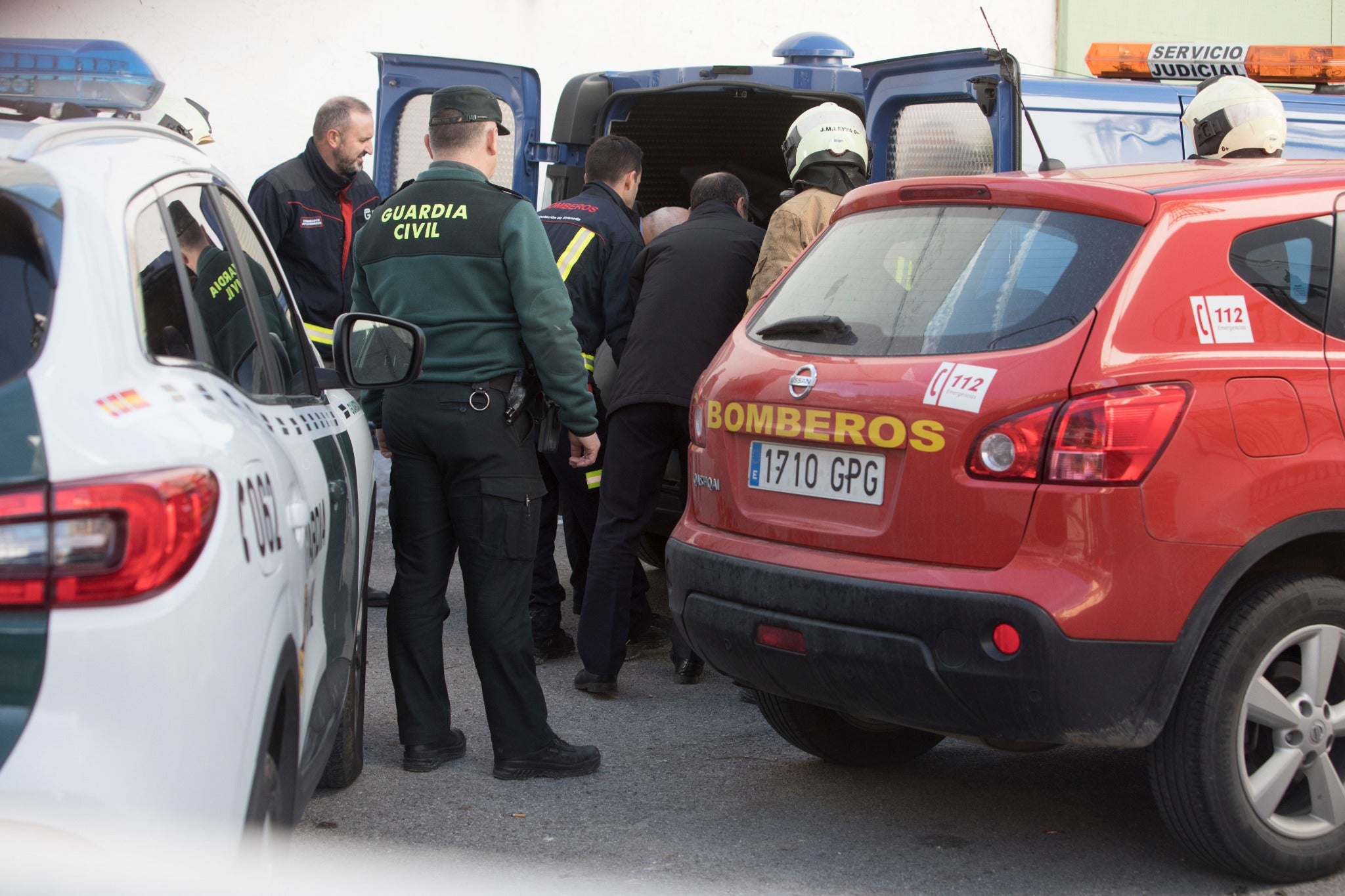 Miembros de la funeraria proceden a guardar uno de los féretros en el vehículo.