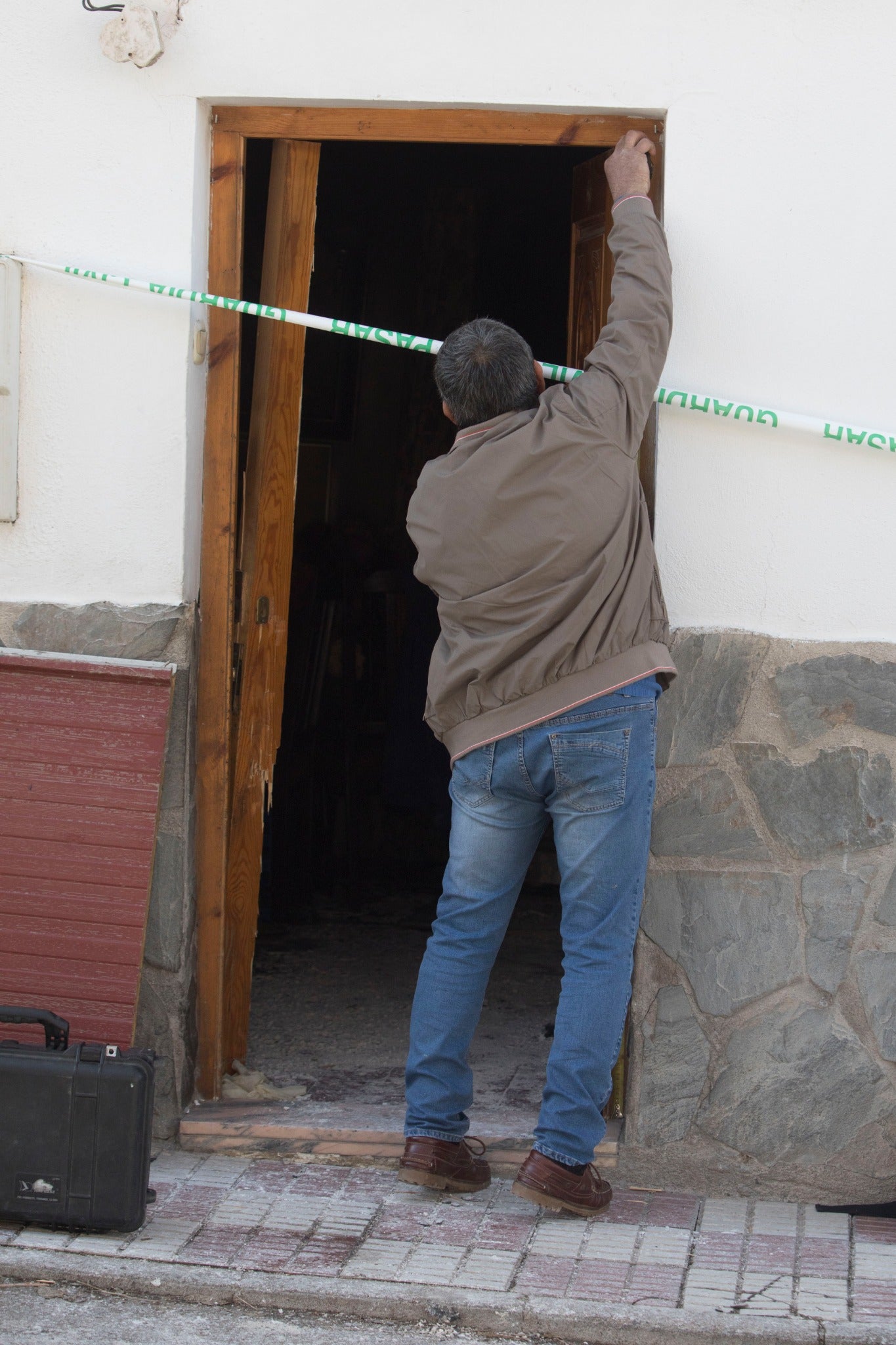 Miembros de la funeraria proceden a guardar uno de los féretros en el vehículo.
