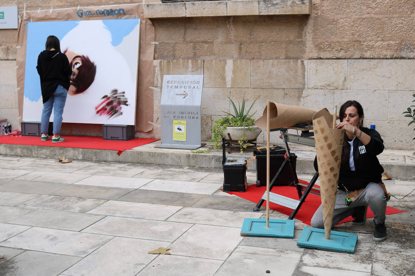 Una joven realiza un grafiti sobre un mural