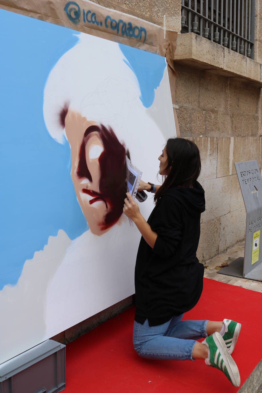 Una joven realiza un grafiti sobre un mural
