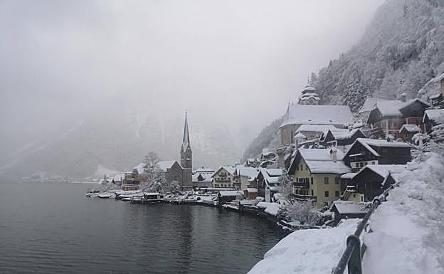 Hallstatt, cubierto de nieve estas navidades. Abajo, hordas de visitantes hacen cola para una excursión en barco