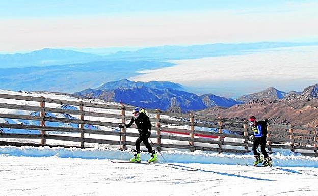 Unos esquiadores de montaña aprovechan la jornada para ascender por el recorrido habilitado este año por la Loma de Dílar.