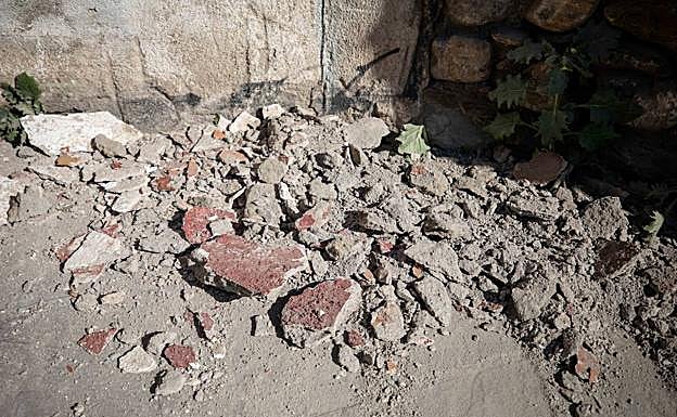 Imagen principal - Los cascotes que ayer cayeron del muro de la Cuesta Escoriaza, y pantallazo de la denuncia presentada a través de la aplicación del Ayuntamiento 'Granada Mejora'.