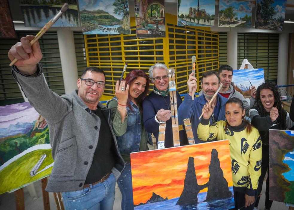 El maestro. Enrique Sáenz, en el centro, posa, pinceles en alto, con parte de sus alumnos. 