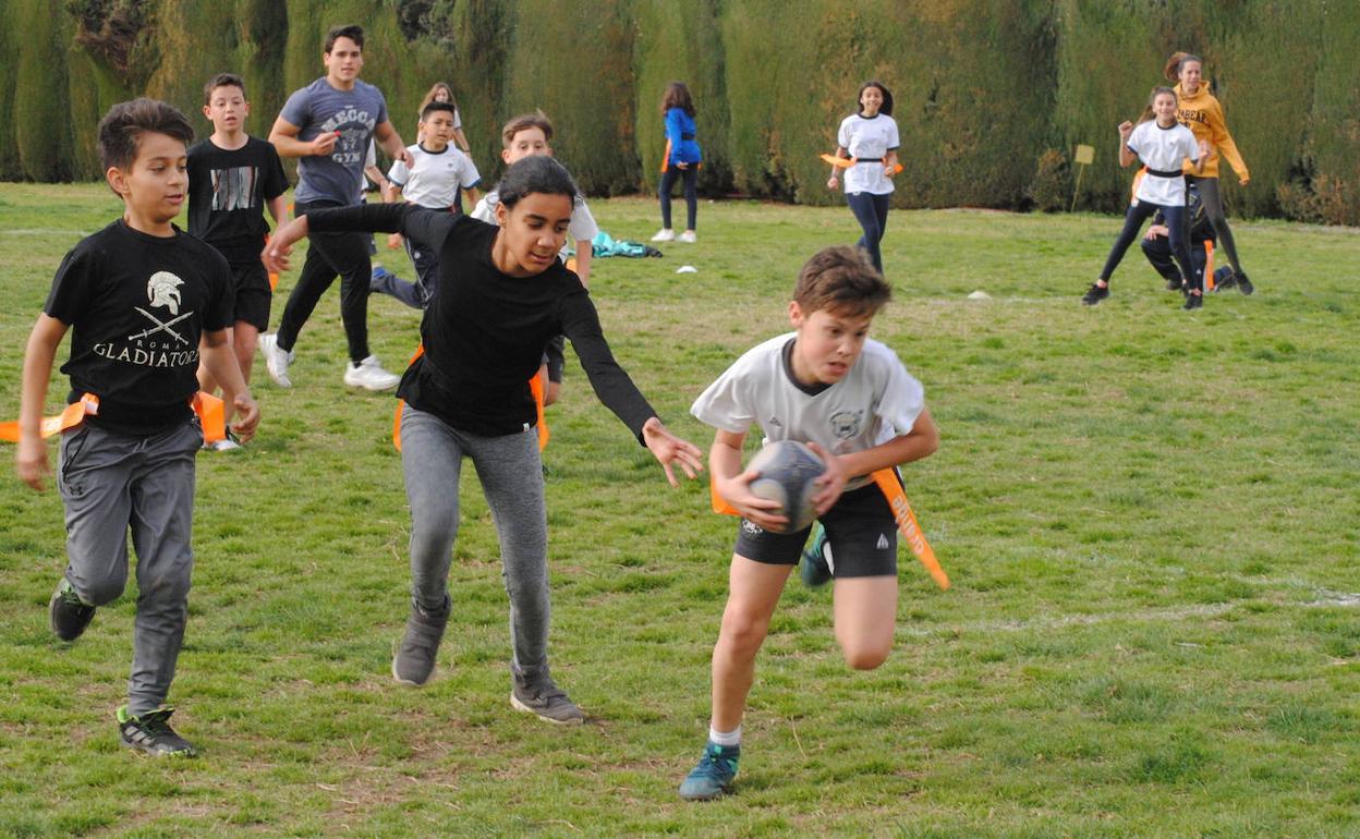 Anotando. Un jugador está a punto de transformar una anotación ante la carrera de una rival, en la hierba natural de Fuentenueva. 