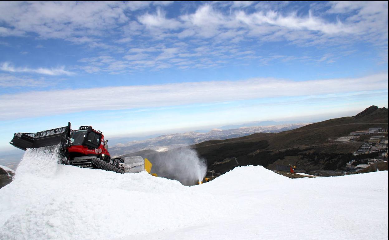 Las máquinas trabajan moviendo la nieve para perfilar la pista de la competición.