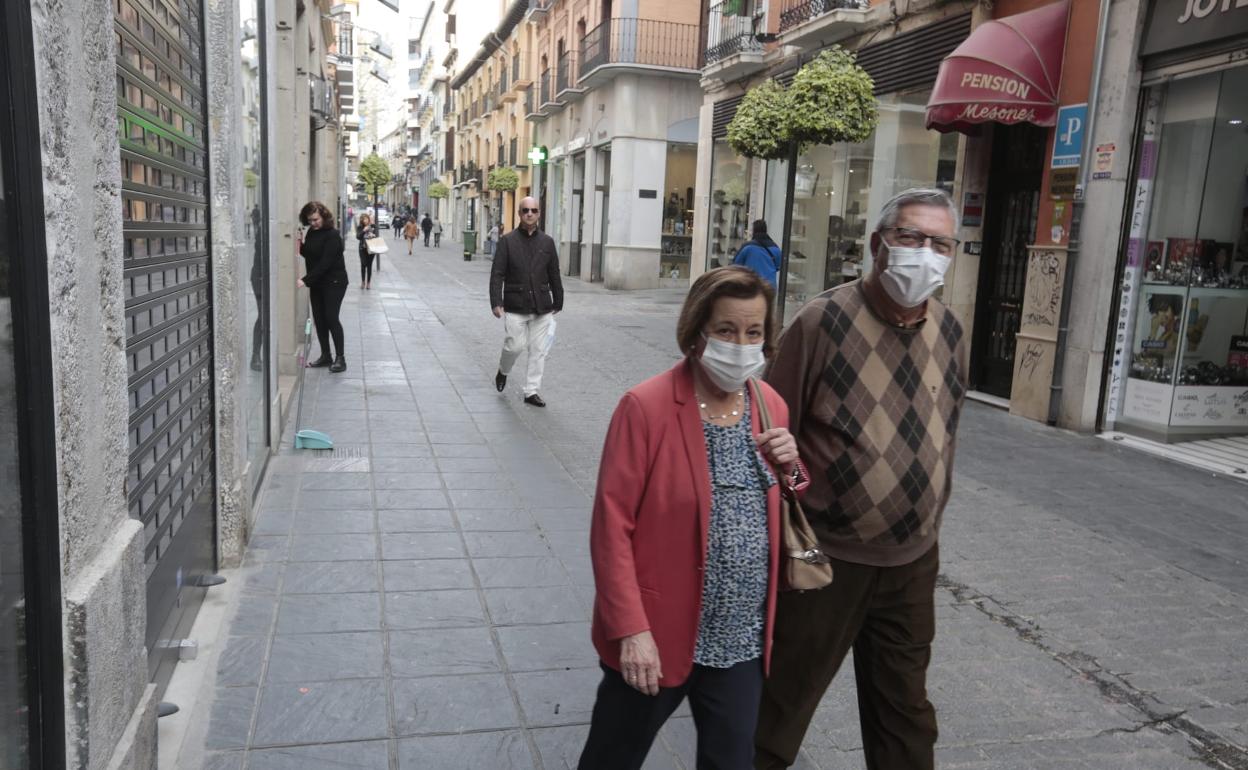 Gente con mascarilas por Granada. 
