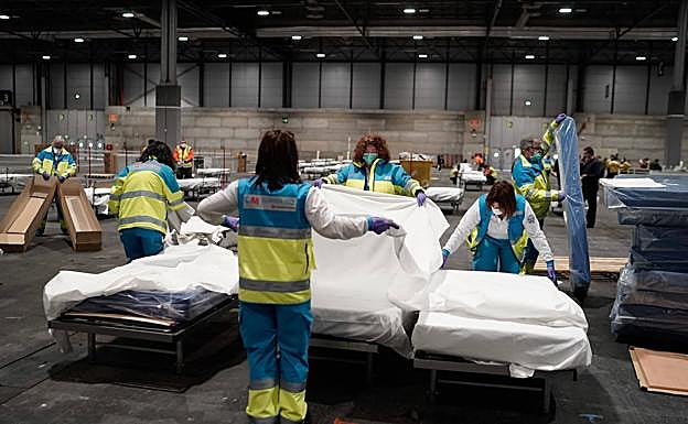 Personal de Emergencias montan las camas en la Feria de Madrid.