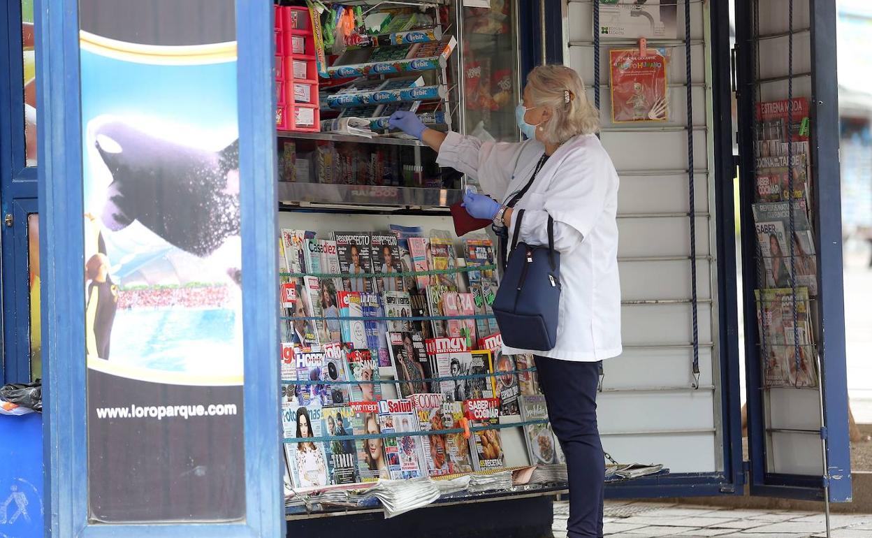 Una mujer compra el periódico en Santa Cruz de Tenerife.