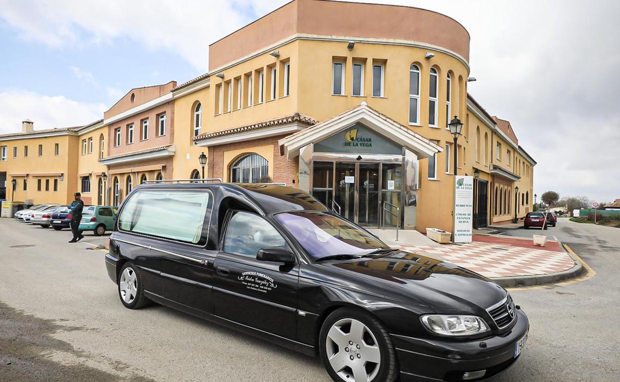 Un coche funerario, a las puertas de la residencia de ancianos de Cájar.