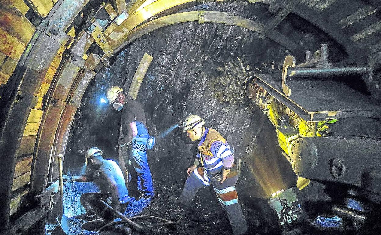 Mineros entiban con postes y trabancas un frente de arranque situado a 700 metros de profundidad en el pozo San Nicolás, en Mieres.