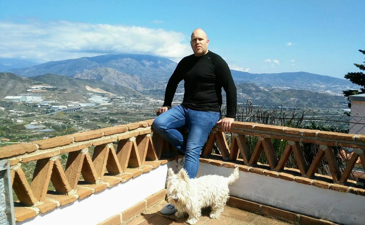 Miguel Ángel, junto a su perro, en la terraza de su casa en Salobreña.