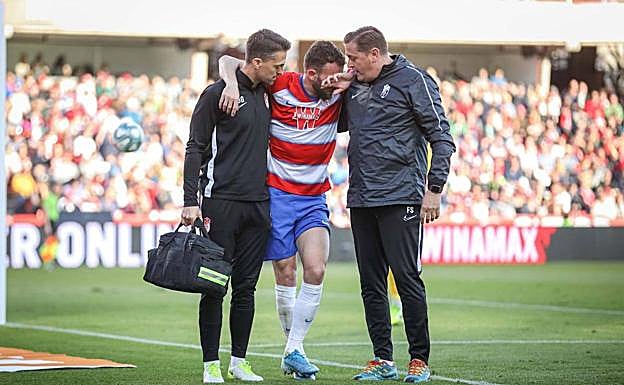 Dioni González y Felipe Segura ayudan a Quini el día que se lesionó, en el pasado mes de diciembre. 