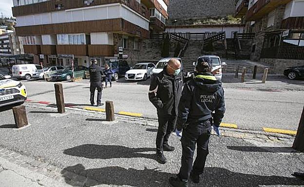Policía Local de Monachil con un vecino y junto a una calle llena de coches en Pradollano ayer.