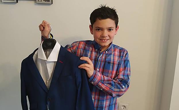 Ricardo Ortega sonríe con su traje de comunión. 