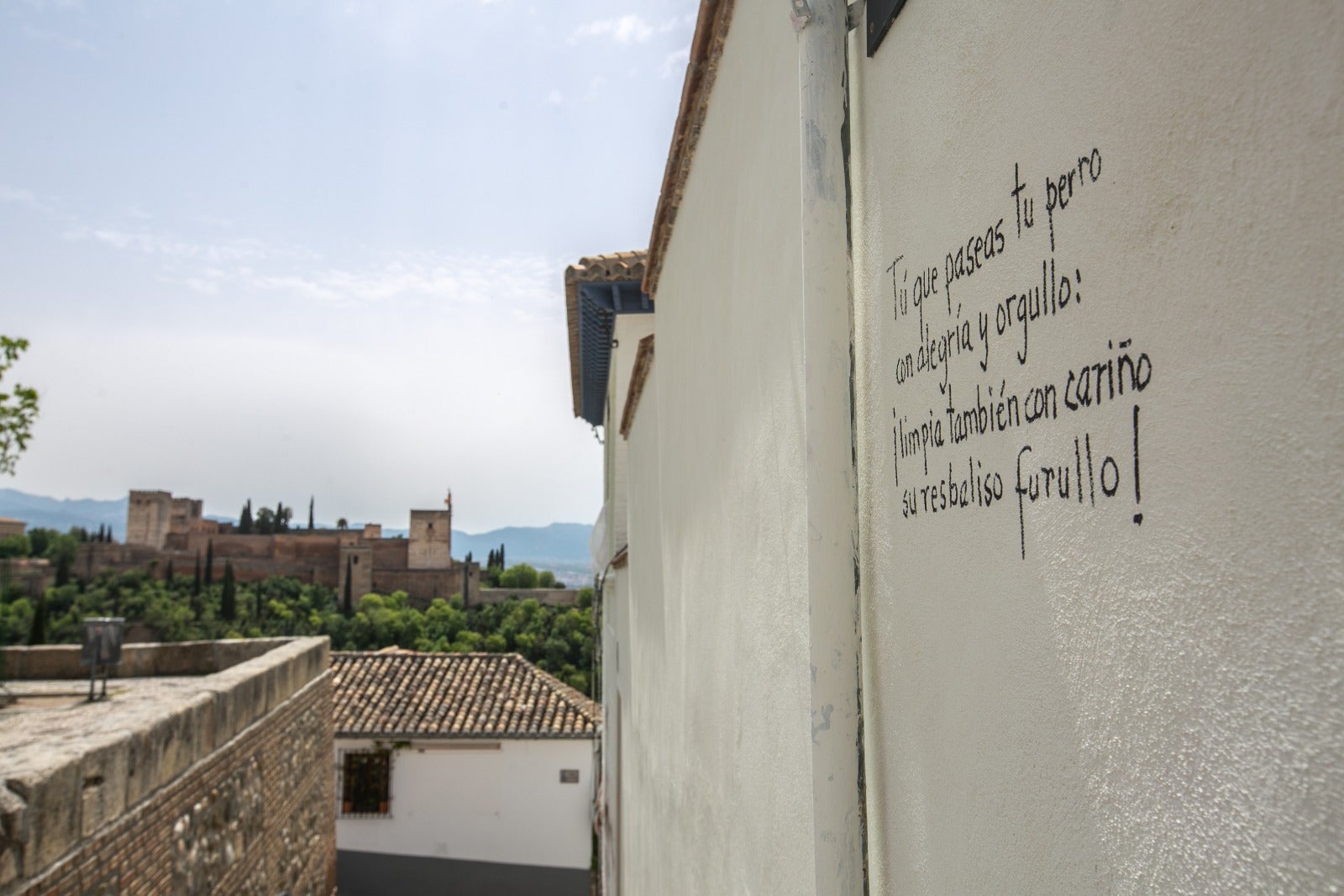 Diferentes poemas en las paredes del barrio recuerdan a los dueños de los canes la importancia de recoger sus heces