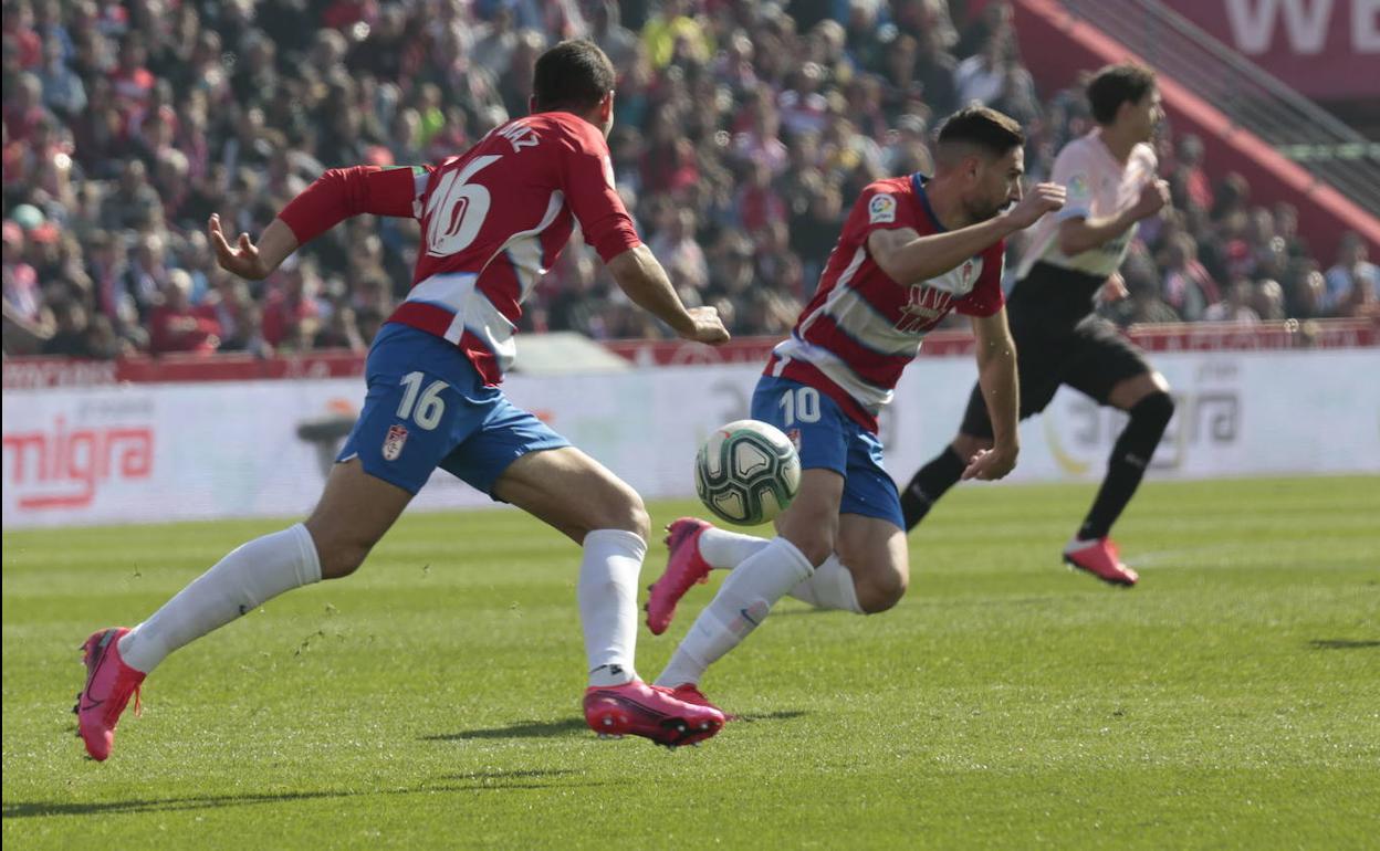 El capitán Víctor Díaz y Antonio Puertas persiguen un balón durante un partido del Granada en Los Cármenes esta temporada. 