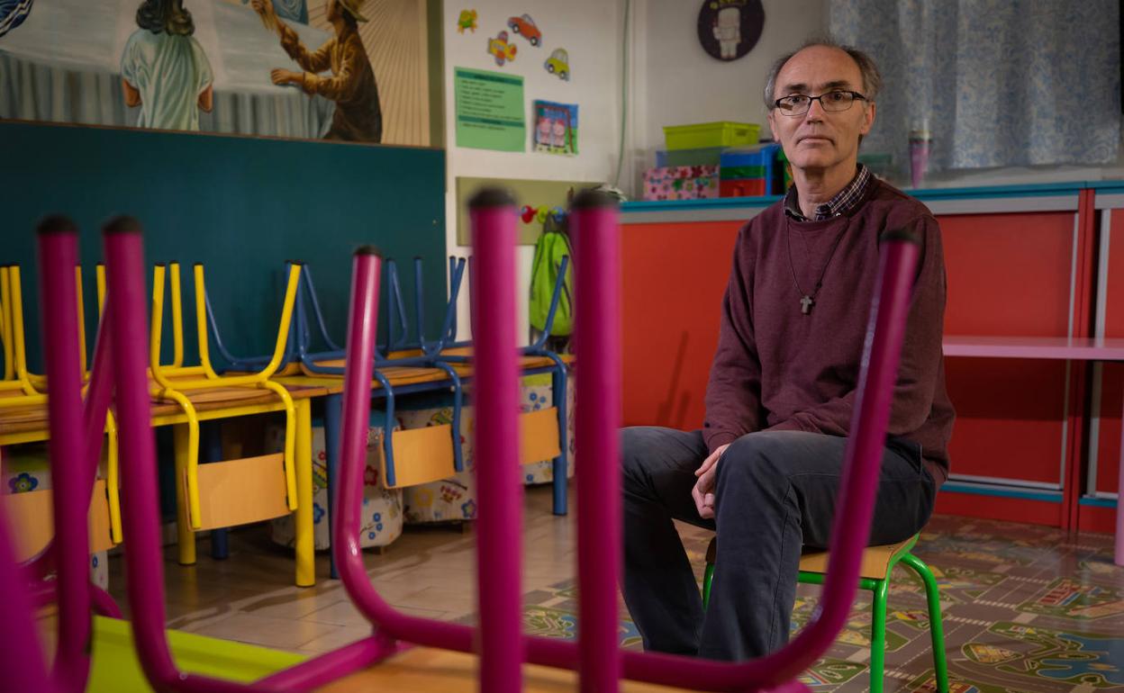 JuanCarlos Carrión, cura de Almanjáyar, sentado en una de las aulas para los peques cerrada por culpa del coronavirus. 