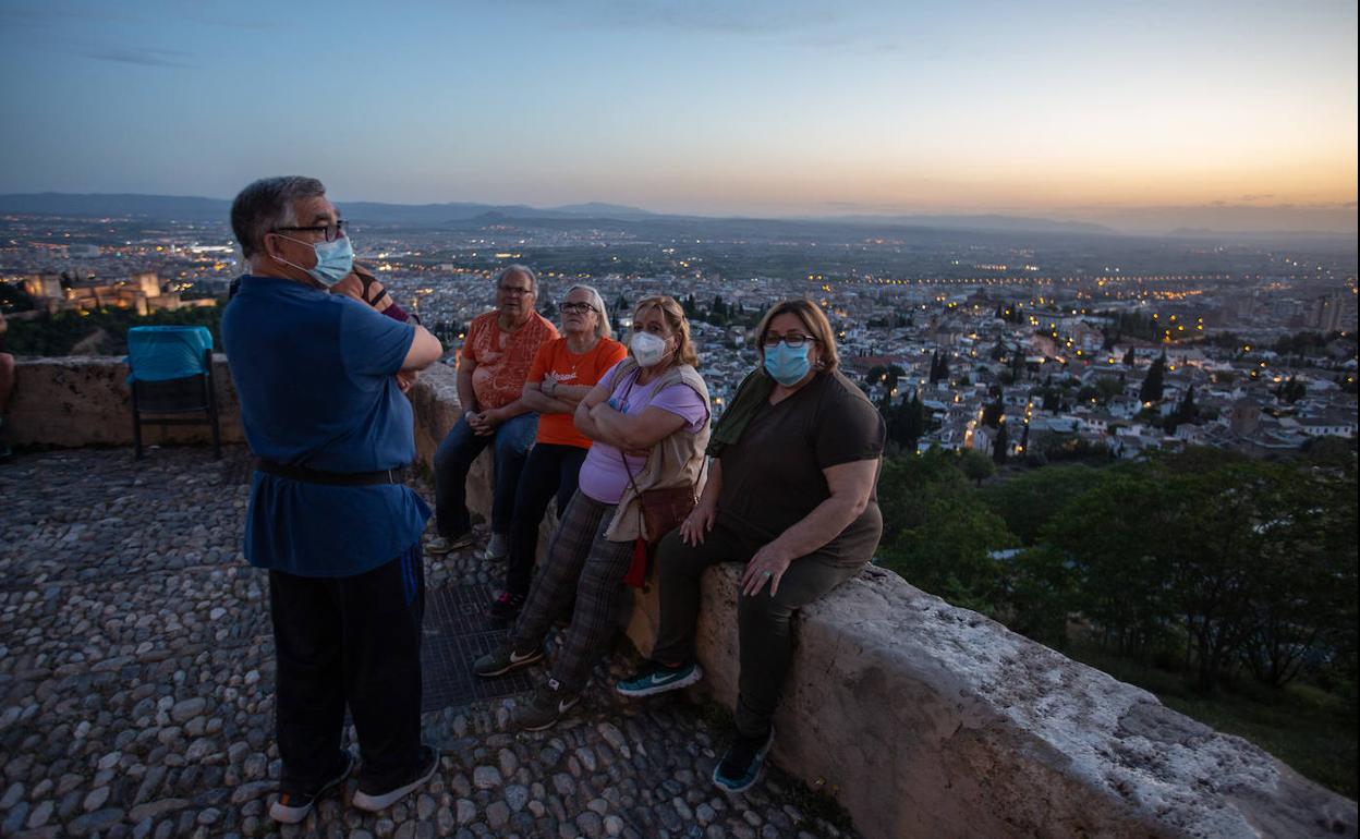 Un grupo de granadinos, en el bordillo de San Miguel. 