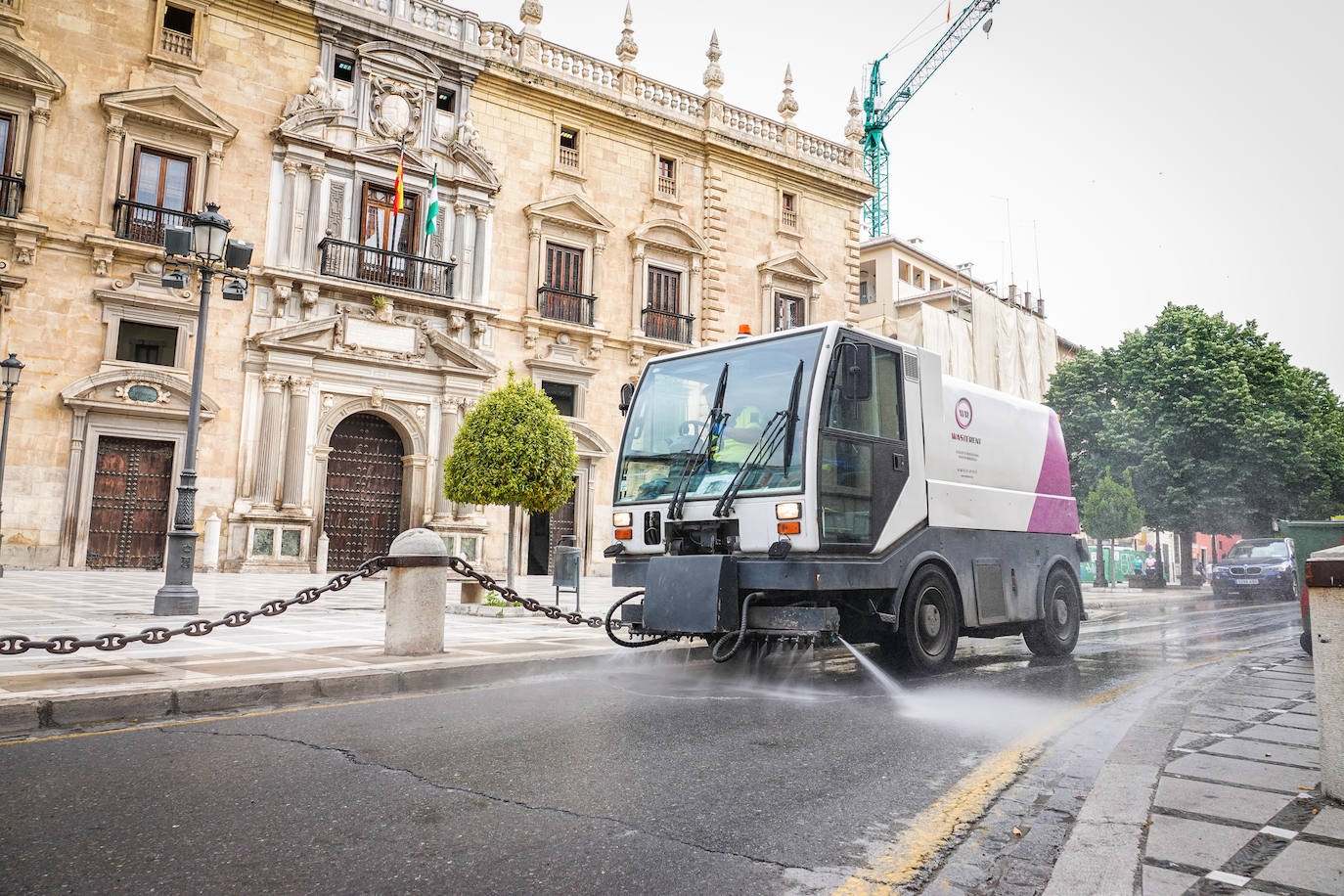 Operarios de Inagra desinfectan el Paseo de los Tristes, con la Alhambra como telón de fondo.