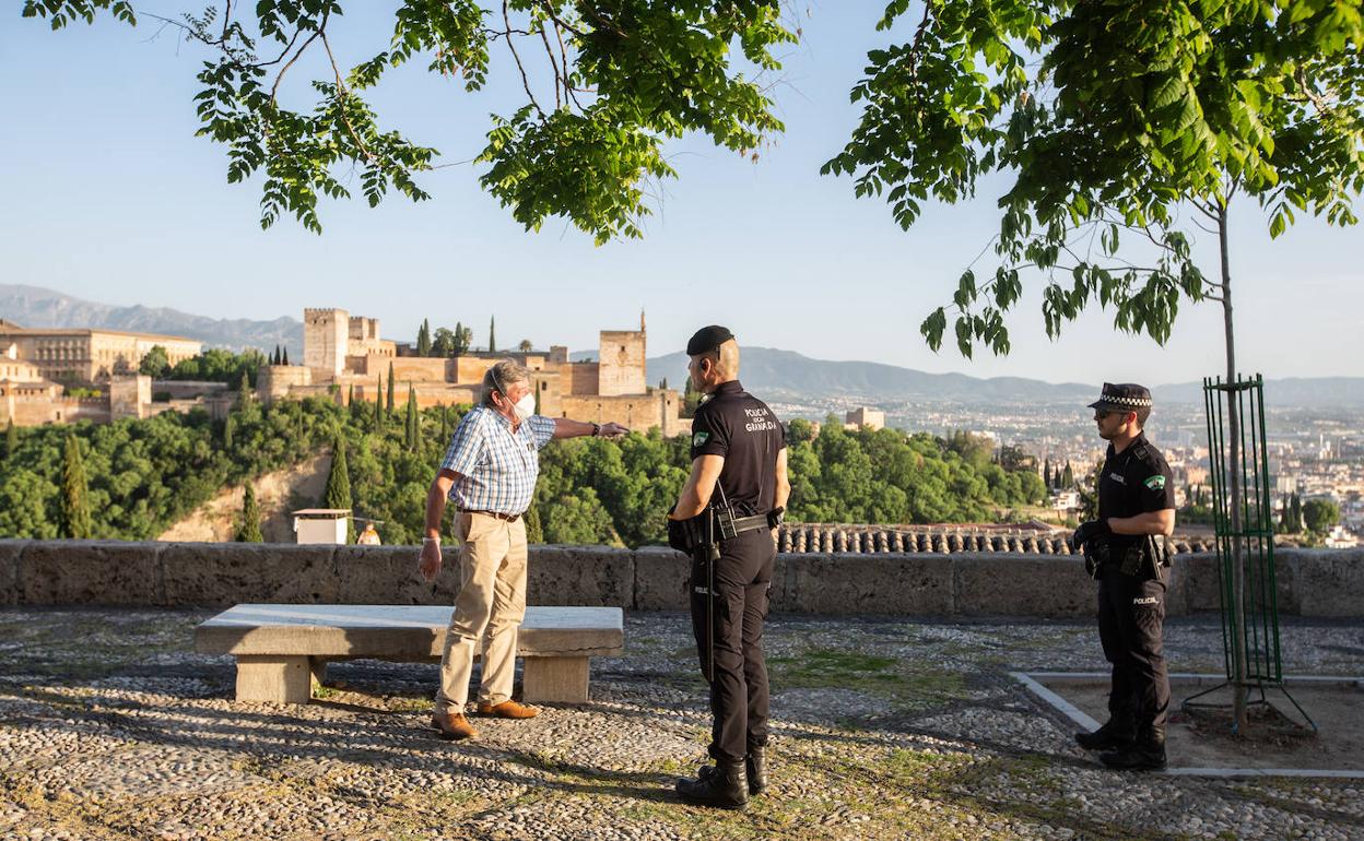 La Policía Local advierte en la tarde del jueves a un hombre de que no puede permanecer sentado en el mirador de San Nicolás.