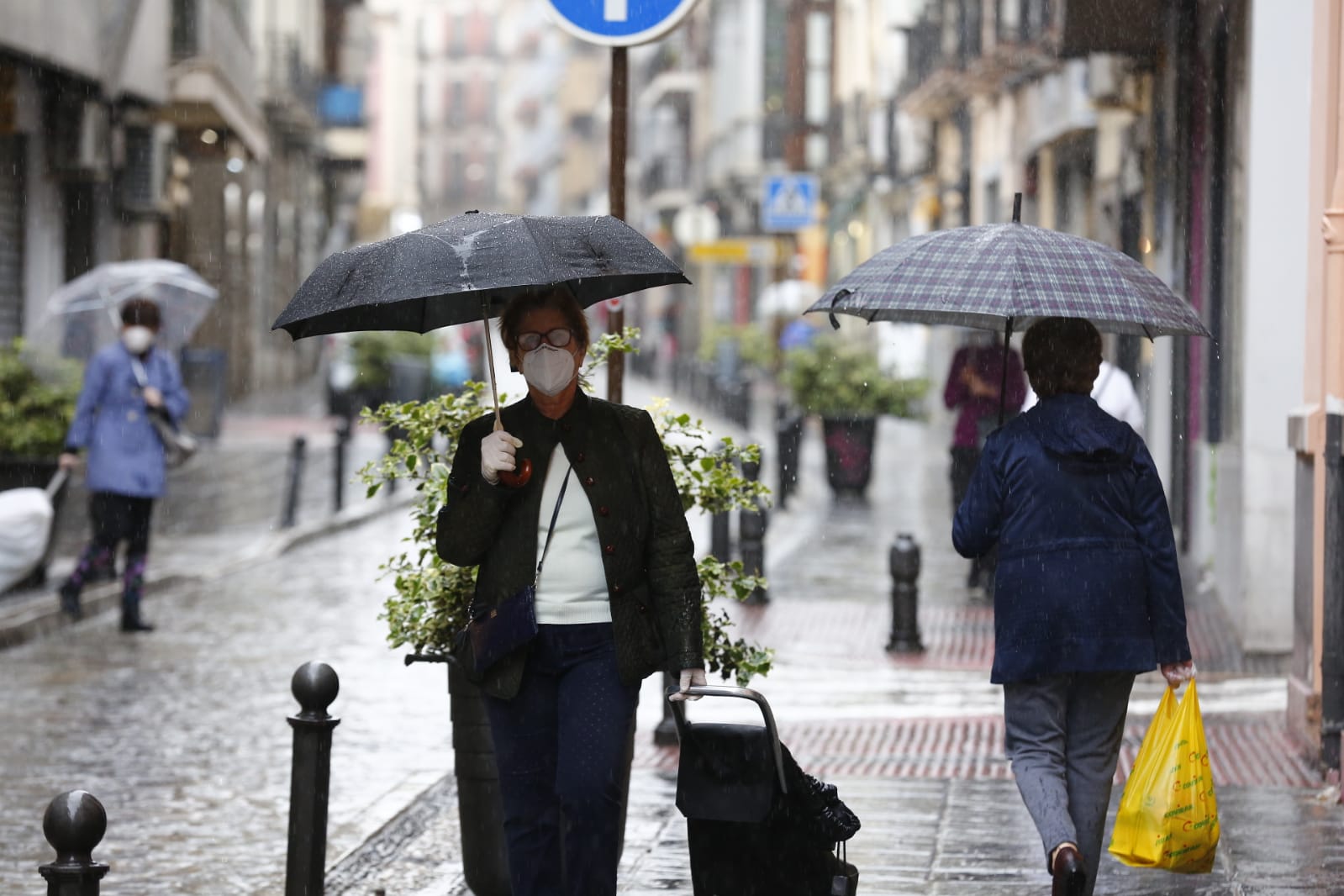 El agua que está cayendo sobre a capital provoca que los granadinos que salen a la calle lo hagan protegidos