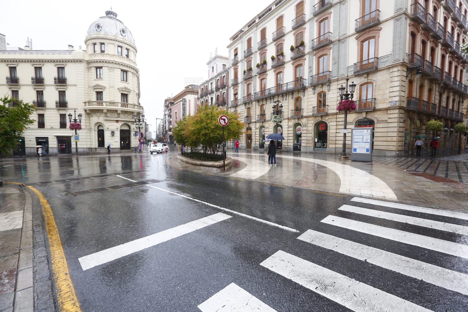 El agua que está cayendo sobre a capital provoca que los granadinos que salen a la calle lo hagan protegidos