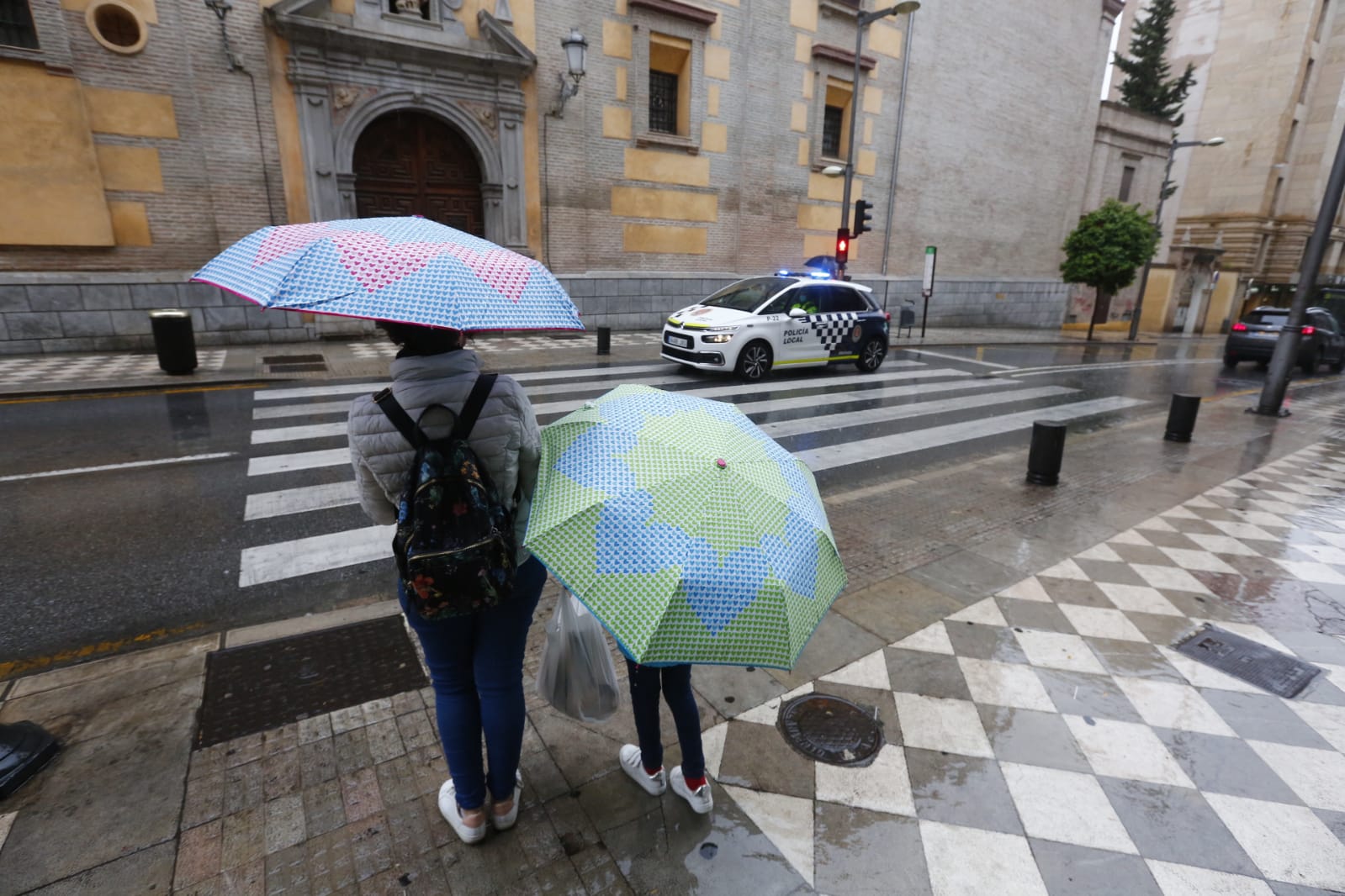 El agua que está cayendo sobre a capital provoca que los granadinos que salen a la calle lo hagan protegidos