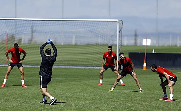 Los futbolistas del Granada realizan el calentamiento manteniendo distancias de seguridad. 