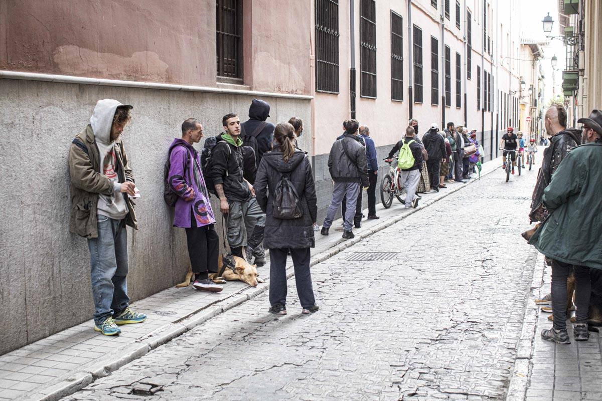 Usuarios esperando la cena en la calle Colegios.