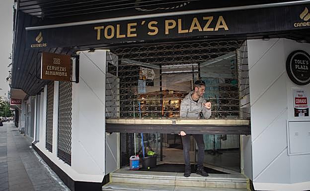Imagen principal - Arriba, José Manuel levanta la persiana como volverá a hacerlo mañana. Debajo, Gabriel con la fregona en Calzados Rosa Maciá, de Acera del Darro, y Toñi limpiando escaparates en Zacatín.